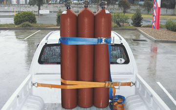 Three acetylene cylinders safety strapped to the back of a truck