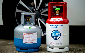 BOC R134a and Opteon refrigerant cylinders next to a car. 
