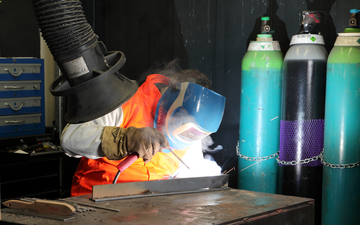 A welder wearing safety equipment demonstrating welding